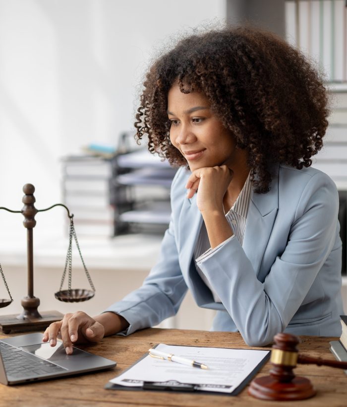 American woman is legal litigation attorney, Female lawyer is in a law firm drafting contracts and reading client case details to study and find a solution to win the case. Lawyer and justice concept.