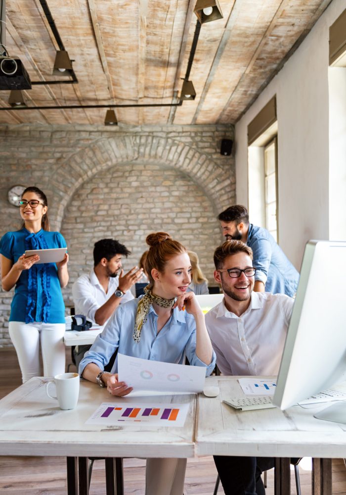 Group of young multi-ethnic startup business team collaborating on project in modern office. Young successful start-up entrepreneurs working as a team together.